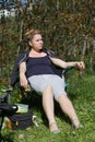 A woman is sitting in a camping chair. Camping during a pandemic