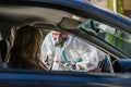 Woman sitting in car, waiting for medical worker in PPE to perform drive-thru COVID-19 test Royalty Free Stock Photo