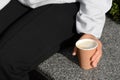 Woman sitting with cardboard cup of coffee outdoors, closeup Royalty Free Stock Photo