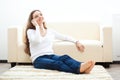 Woman sitting on carpet and talking by phone Royalty Free Stock Photo