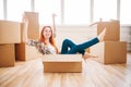 Woman sitting in carton box, housewarming