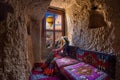 Woman sitting in cave house and looking to windows with beautiful scenic in Goreme, Cappadocia, Turkey. Royalty Free Stock Photo