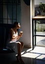 Woman sitting in chair and enjoying first morning coffee on sunshine. perfect morning with coffee. woman relax in chair Royalty Free Stock Photo