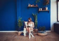 Woman sitting on chair in the morning, reading book, curly hair, feeling comfortable at home Royalty Free Stock Photo