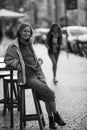 A woman sitting on a chair outside a sidewalk cafe, Portugal. Black and white photo. Royalty Free Stock Photo