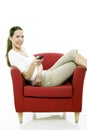 Woman sitting on a chair with remote control Royalty Free Stock Photo