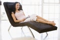 Woman sitting in chair with remote control Royalty Free Stock Photo