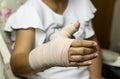 Woman sitting on a chair with Splint broken bone on her hand