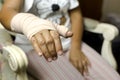 Woman sitting on a chair with Splint broken bone on her hand