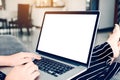 Woman sitting on chaise longue and using laptop blank screen at