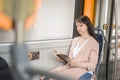 a woman sitting on a cityb bus reading a book. passenger in public transport Royalty Free Stock Photo