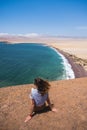 Woman sitting on a cliff, back