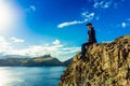 Woman sitting on a cliff on Ponta de Sao Lourenco peninsula, Madeira, Portugal