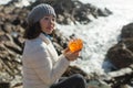 A woman sitting with a cocktail on the ocean rocks Royalty Free Stock Photo