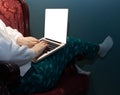 A woman is sitting comfortably in a chair with her hands on the keyboard of a laptop, close-up, side view Royalty Free Stock Photo