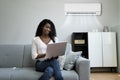 Woman Sitting On Couch With Air Conditioner Royalty Free Stock Photo