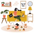 Woman sitting on the couch with cat, daughter playing with cute corgi on the floor, indoor in living room. Young mother working