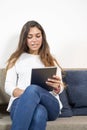 Woman, sitting on a couch, talking to someone using voip service