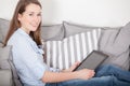 Woman sitting on couch and uses tablet device