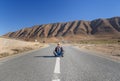 Woman sitting with cross leg on the road. Fork in the road. Morocco Royalty Free Stock Photo