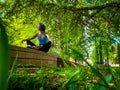 woman sitting cross-legged meditating in a park Royalty Free Stock Photo