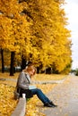 Woman sitting on a curb and writing something in her notebook Royalty Free Stock Photo