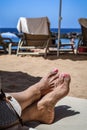 View of a woman`s feet on deck chair at a beach. Royalty Free Stock Photo
