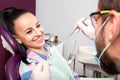 Woman sitting in dental chair while doctor examining her teeth