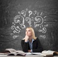 Woman sitting at the desk with books around thinking education