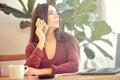 Woman sitting at the desk and talking on the phone. employee break, office employee is distracted from work Royalty Free Stock Photo