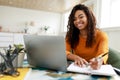 Woman sitting at desk, using computer and writing in notebook Royalty Free Stock Photo