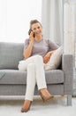 Woman sitting on divan and talking cell phone Royalty Free Stock Photo