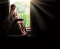 A woman sitting at the door and reading a book