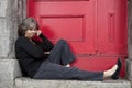 Woman sitting on door stoop