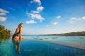 Woman sitting on the edge of infinity pool Royalty Free Stock Photo