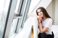 Woman sitting on the end of bed near big window Royalty Free Stock Photo