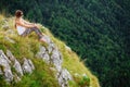 Woman sitting at the end of earth in fascinating landscape Royalty Free Stock Photo