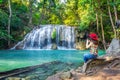 Woman sitting at Erawan waterfall in Thailand. Beautiful waterfall with emerald pool in nature. Royalty Free Stock Photo