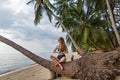 Woman sitting on a fallen palm tree