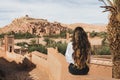 Woman sitting on fence with view of famous moroccan old town in Ouarzazate Royalty Free Stock Photo