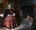 A Woman Sitting by a Fireplace with Pancakes