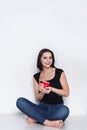 Woman sitting on floor with cup of tea or coffee