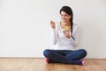 Woman Sitting On Floor Eating Bowl Of Fresh Fruit Royalty Free Stock Photo