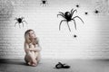 Woman sitting on the floor and looking on imaginary spider. Royalty Free Stock Photo