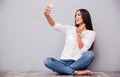 Woman sitting on the floor and making selfie photo Royalty Free Stock Photo