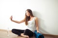 Woman sitting on floor and making selfie on smartphone in fitness gym Royalty Free Stock Photo