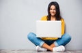 Woman sitting on the floor and using laptop