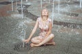 Woman is sitting in a fountain. Royalty Free Stock Photo