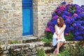 Woman sitting in front of door of old stone cottage. Royalty Free Stock Photo