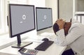 Woman sitting in front of office computers and waiting for software update to install